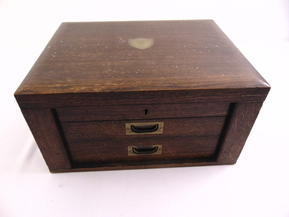 A rectangular oak flatware case with fitted interior, hinged top with two drawers