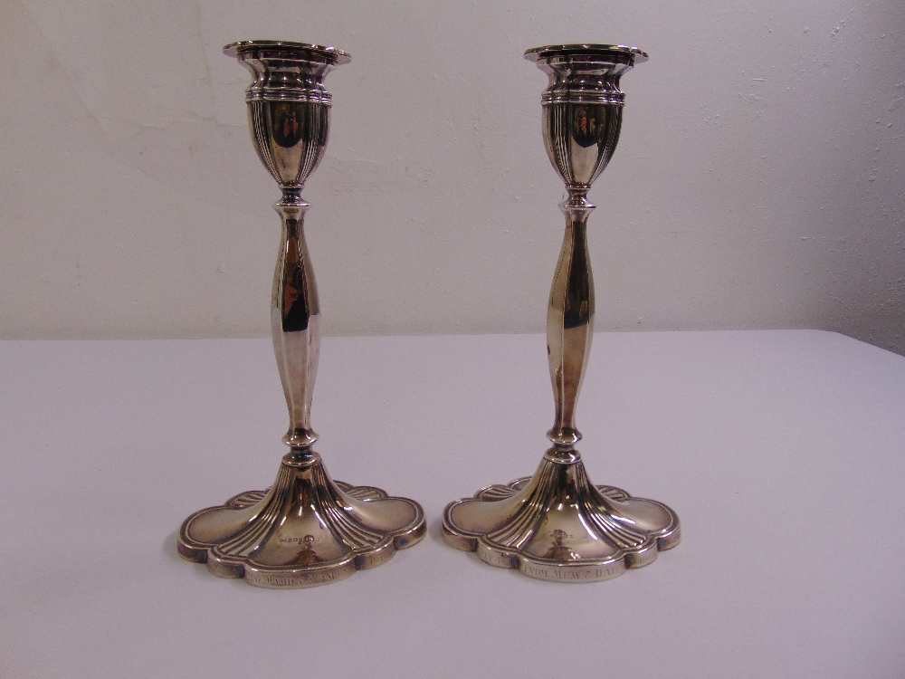 A pair of silver table candlesticks facetted baluster form on fluted shaped oval bases with vase