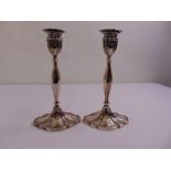 A pair of silver table candlesticks facetted baluster form on fluted shaped oval bases with vase