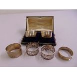 A quantity of silver napkin rings to include a pair in fitted case and four others