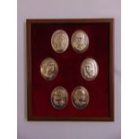 A framed montage of six silver plaques depicting members of the Royal Family