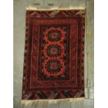 Persian wool carpet red and orange ground with repeating geometric pattern and border, 107 x 73cm
