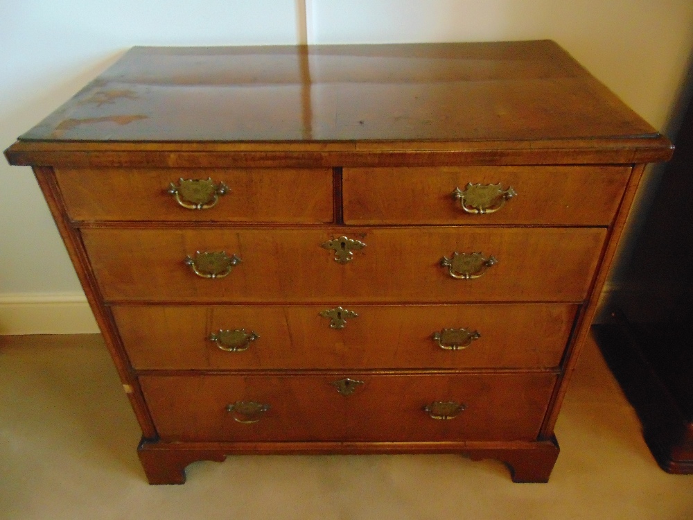 A Georgian rectangular mahogany chest of drawers with brass swing handles, on four bracket feet