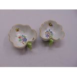 A pair of Herend bonbon dishes of leaf form decorated with flowers and butterflies, marks to the