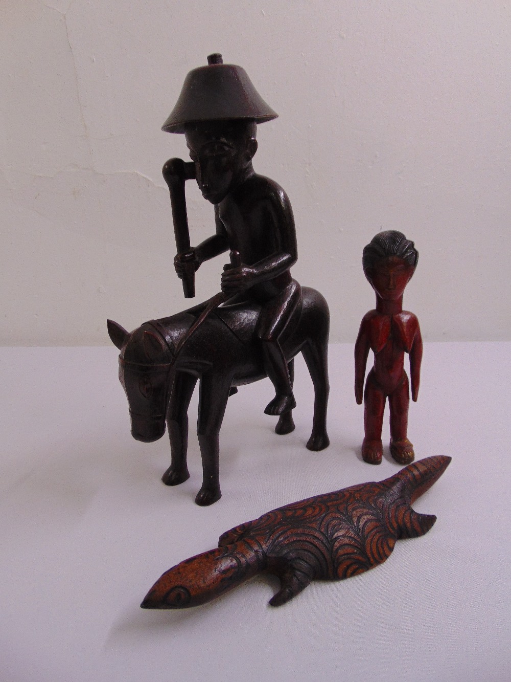 A quantity of Senufo Ivory Coast tribal carved wooden figurines to include a man wearing a hat on