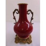 Chinese ox blood baluster vase mounted on gilded metal base and with gilded metal side handles
