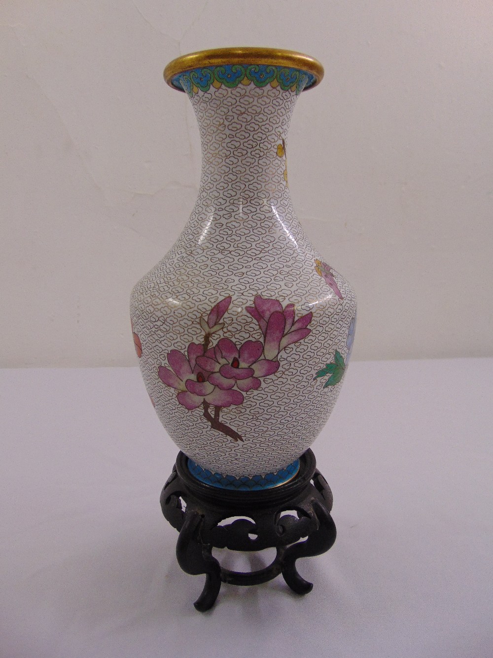 A cloisonné baluster vase inlaid with floral sprays on a pierced hardwood stand