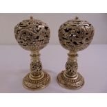 A pair of Chinese white metal incense burners of pierced globular form on baluster stands and raised