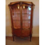A French style two door glazed Kingswood display cabinet with applied gilded metal mounts
