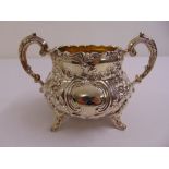 A Victorian silver sugar bowl of baluster form chased with flowers and leaves with capped double