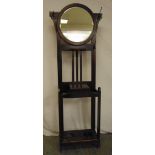 A Victorian oak hall hat stand in arts and crafts form with oval mirror and integrated umbrella