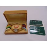 Gucci gold plated ladies wristwatch with interchangeable coloured bezels, in original packaging