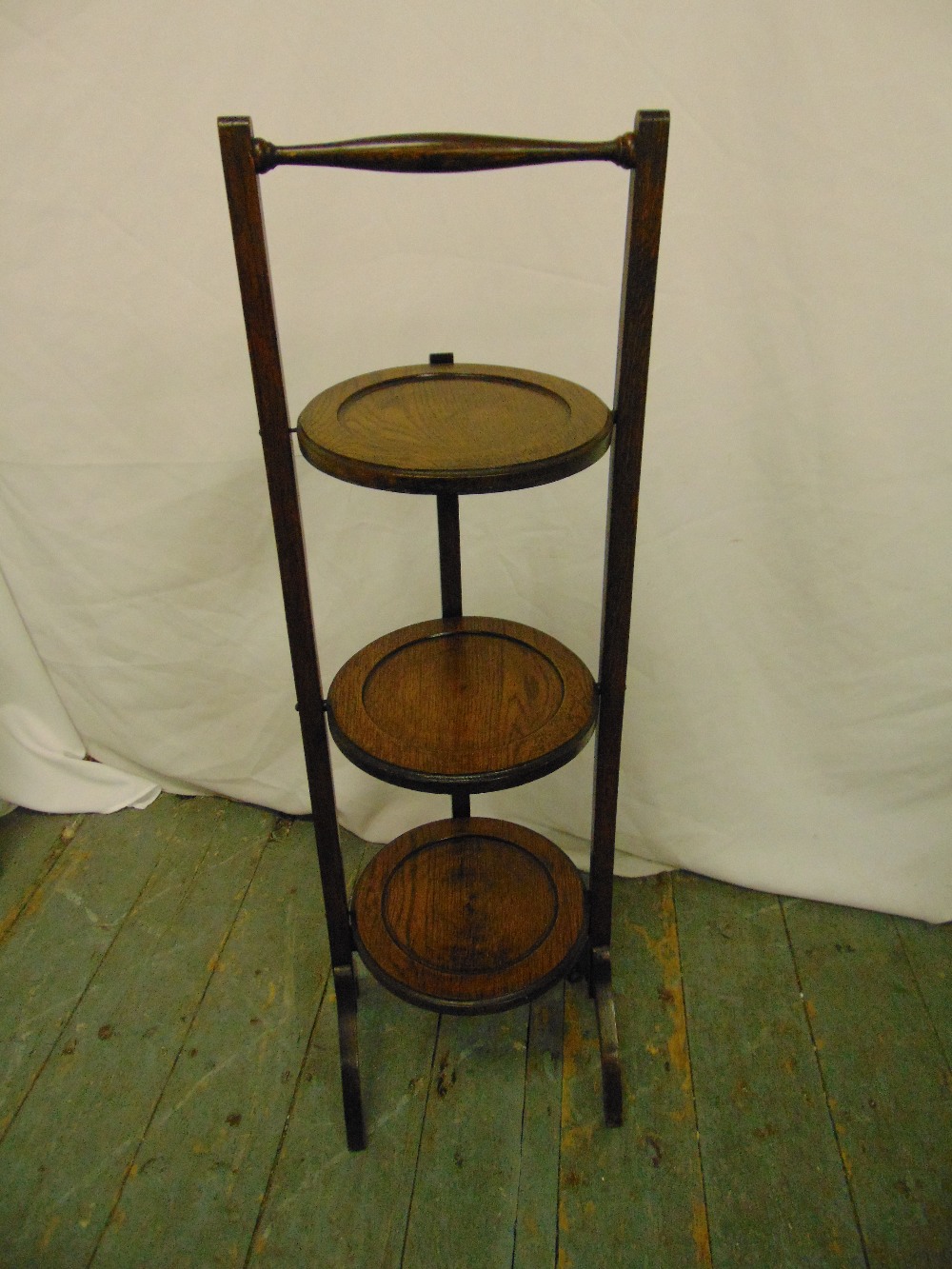 An oak three tier plate stand of customary form