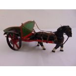 A carved wooden model of a horse and carriage