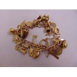 A 9ct yellow gold charm bracelet with 28 charms, approx total weight 39.7g