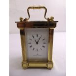 A Matthew Norman brass carriage clock flanked by fluted columns and with carrying handle