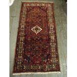 Persian wool runner red ground with green and blue repeating pattern and cream border, 200 x 104cm
