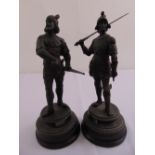 A pair of spelter figurines of armoured soldiers on raised circular plinths