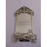 A silvered Art Nouveau style table mirror shaped rectangular with stylised vegetation and a