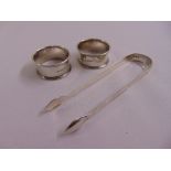 Two silver napkin rings and a pair of George III silver tongs