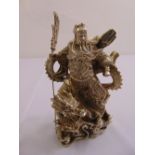 A Chinese white metal figurine of a warlord riding a dragon