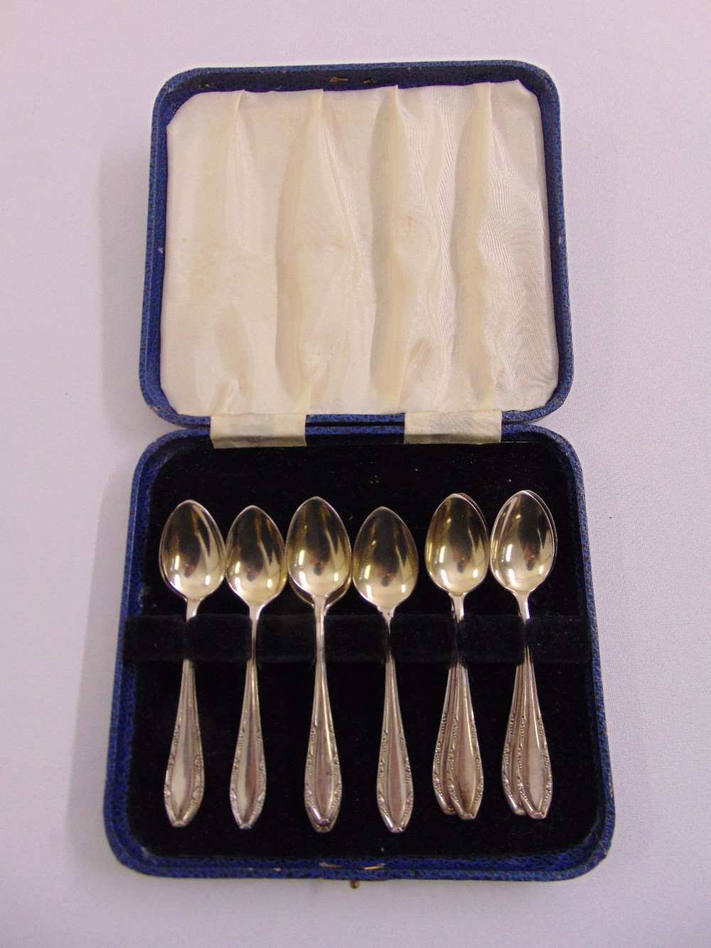 A cased set of ten white metal teaspoons