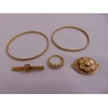 A quantity of 9ct gold jewellery to include two bangles, two brooches and a ring, approx total