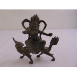 A Tibetan bronze deity riding a dragon