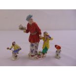 A Meissen chinoiserie figural group of a lady carrying a tea tray and boy with a bird, a Meissen