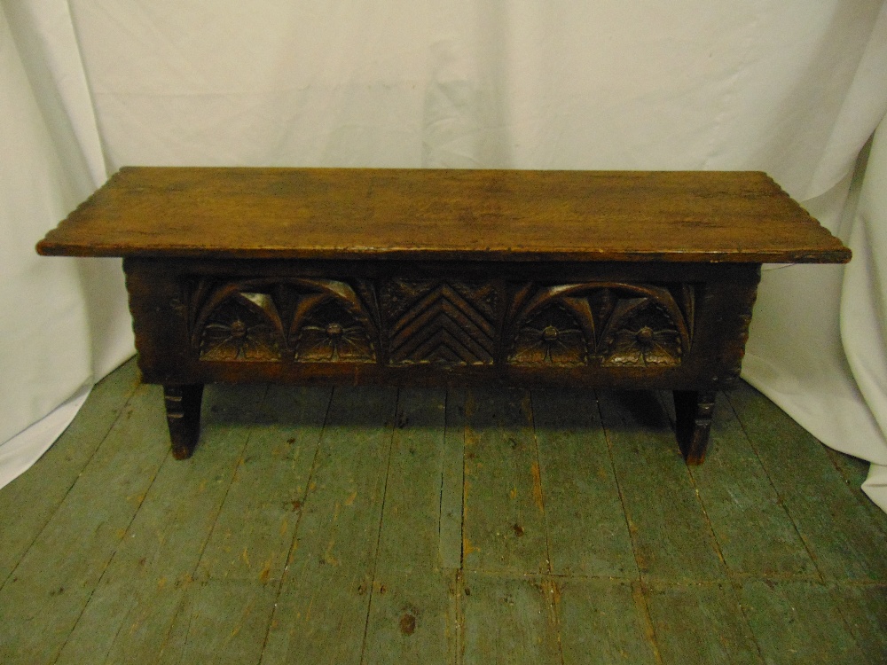 A rectangular oak monks bench with carved sides, hinged cover on four turned legs