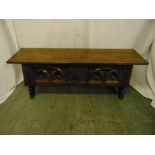 A rectangular oak monks bench with carved sides, hinged cover on four turned legs