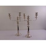 A pair of silver plated candelabra tapering cylindrical on raised circular base with gadrooned