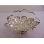 A Victorian silver cake basket, lobed and pierced circular form with swing handle on raised circular