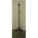 A wrought iron free standing floor candle holder on three scroll supports