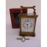 A brass carriage clock of customary form in leather case, to include key