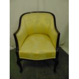 An early 20th century upholstered tub chair on scroll legs