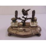 A silver plated desk set with two glass inkwells and a cast figurine of a bird on a branch on a
