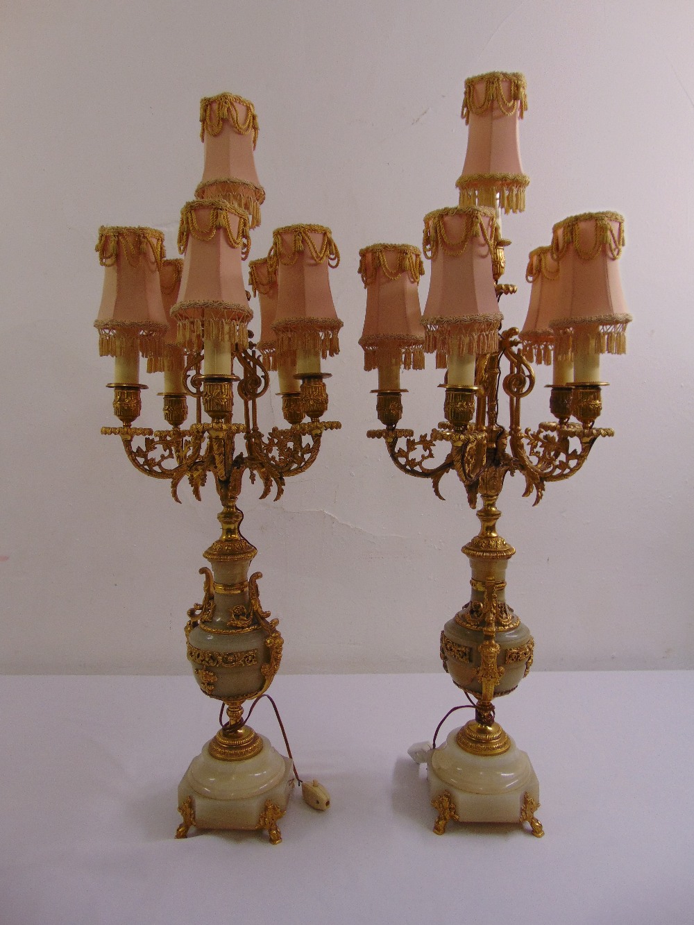 A pair of continental gilded metal and white marble five light candelabra table lamps with silk