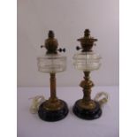 A pair of late 19th century metal oil lamps with glass reservoirs converted to electricity