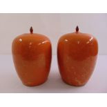 A pair of 19th century Chinese orange ground vases with pull off covers with bud finials