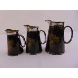 Three graduated St Albans jugs of customary form