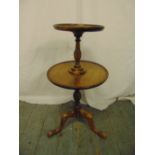 A mahogany circular two tier tea table on three outswept legs