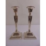 A pair of silver neo-classical style table candle sticks, tapering rectangular on raised square
