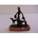 A bronze figural group of a lady with two dogs on shaped rectangular marble plinth