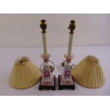 A pair of porcelain table lamp stands decorated with floral sprays and with shades