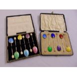 Two cased sets of silver and enamel coffee spoons