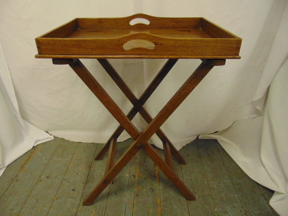 A rectangular wooden butlers tray on articulated stand