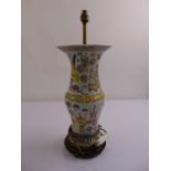 An early Chinese porcelain table lamp decorated with stylised leaves and furniture on carved