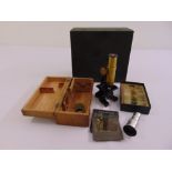 A travelling brass microscope in fitted case, approx 20 prepared slides and magic lantern slides