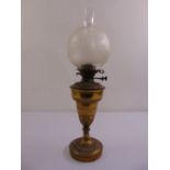 A Victorian brass oil lamp with glass shade on raised circular base